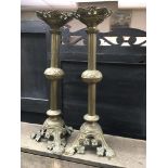 A pair of brass gothic style candle sticks 62 cm .