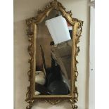 A gilt framed wall mirror with folate scrolls 50x1