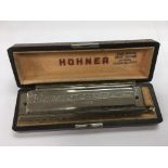 Two harmonicas including a cased Hohner example.