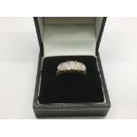 A 9ct gold ring set with five opals and diamond ch