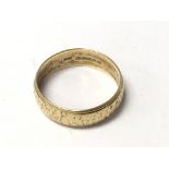 An 18carat gold wedding ring with a patterned edge