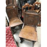 A pair of Gothic carved oak hall chairs.