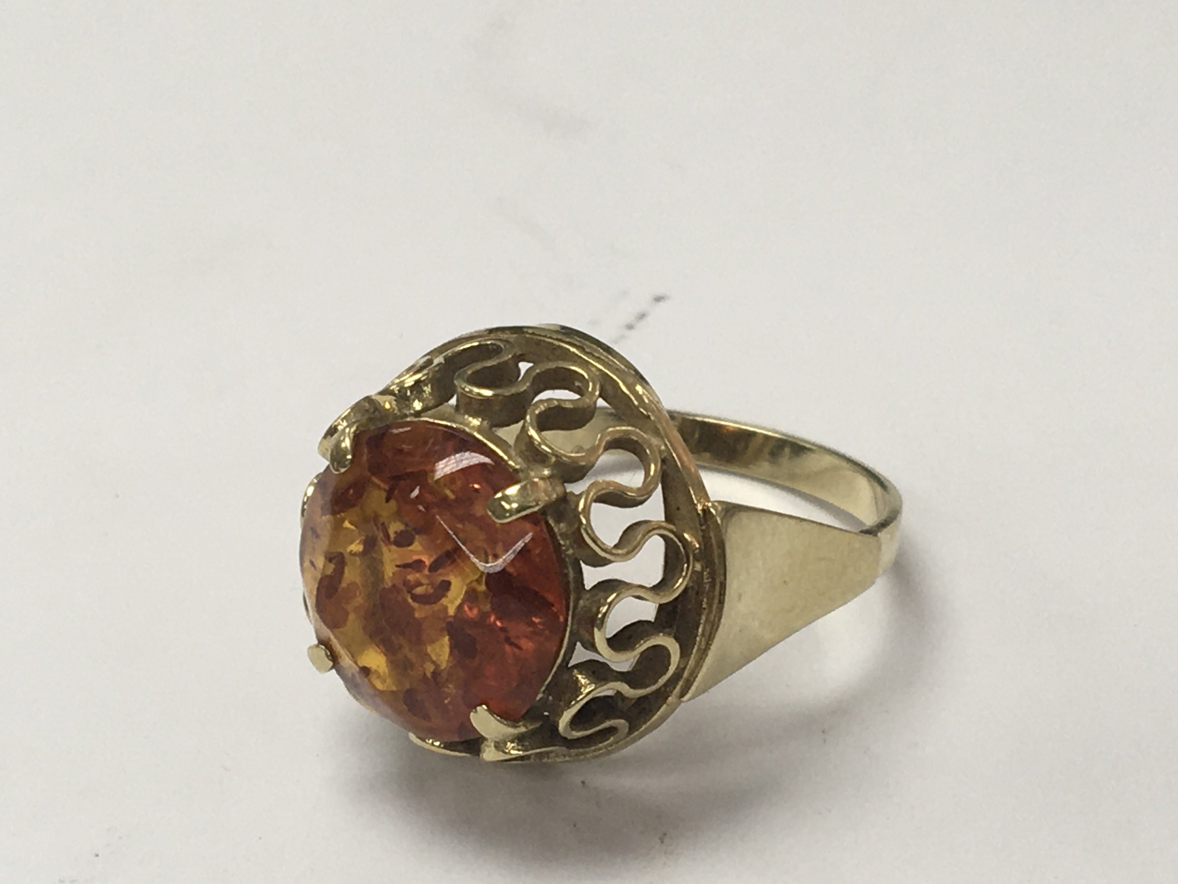 A gold ring stamped 585 inset with an amber stone