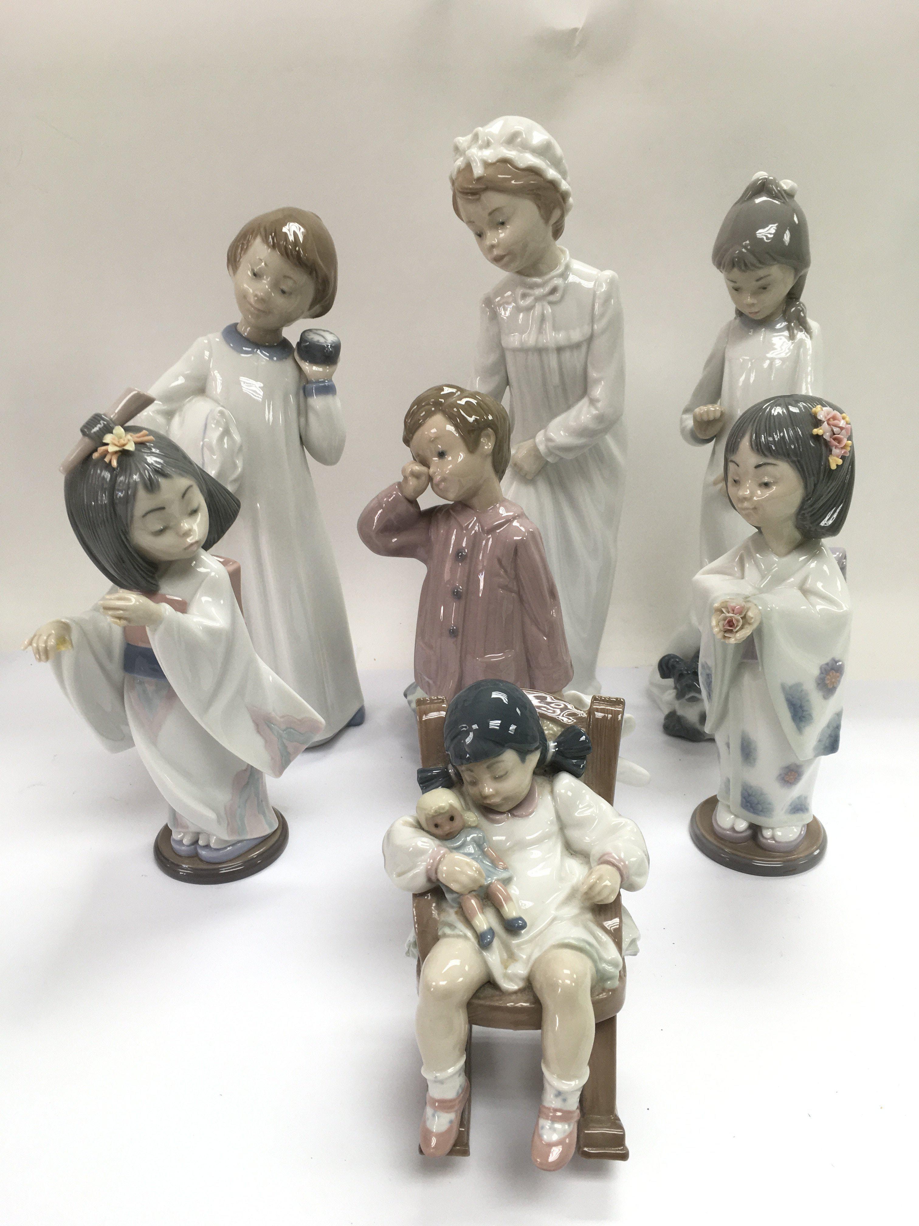 A collection of Lladro and Nao figures of children