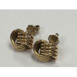 A pair of unmarked gold earrings woven Knott’s wit