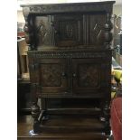 A small carved oak 17th century style cupboard wit