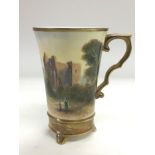 A hand painted porcelain cup depicting a view of K