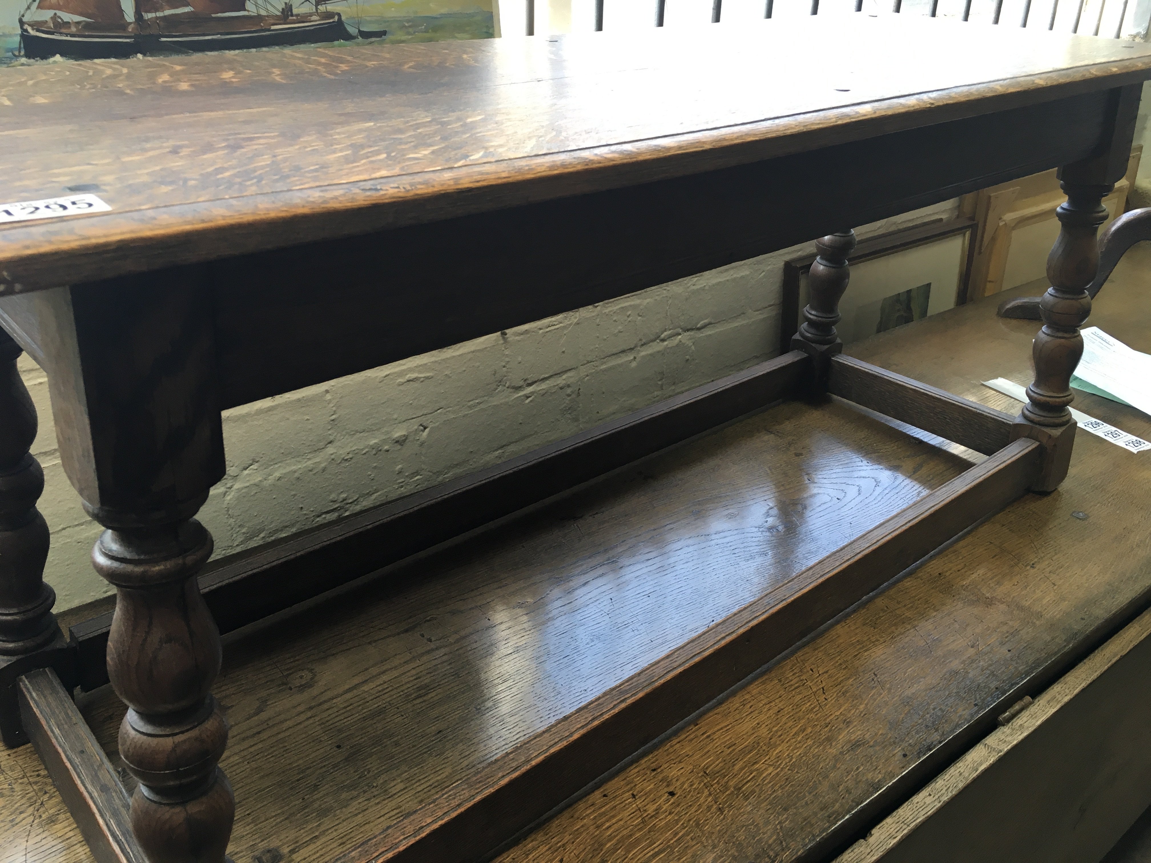 A oak window seat on turned legs United by stretch