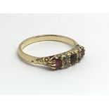 A pn unmarked gold ring set with garnets and small