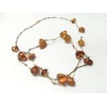 An amber necklace with gold plated bar links and i