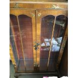 A walnut double door display cabinet with chinoise