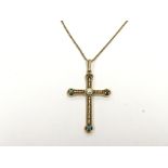An unmarked gold pendent cross set with turquoise
