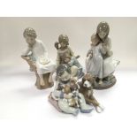 Four Lladro figural groups of children.