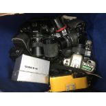 A box of mixed cameras and lenses.