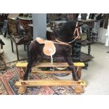 A large modern Mamas & Papas brown rocking horse w