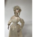 A wax headed doll on stand 33 cm