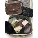 A small vintage case containing a variety of small handbags of various designs and a small fur