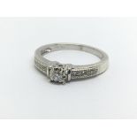 A 9ct white gold solitaire diamond ring with furth