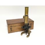 A brass student microscope in wooden fitted case