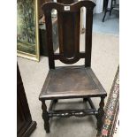 An Early 18th century oak chair with a panelled back and solid seat on turned legs.