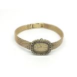A ladies Bueche Girod 9ct gold watch with a diamond surround and baton numerals, approx weight 22.