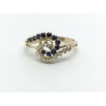 An 18ct gold sapphire and diamond swirl design rin