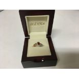 An 18carat yellow gold ring set with a ruby and small diamonds with a shaped double line shank
