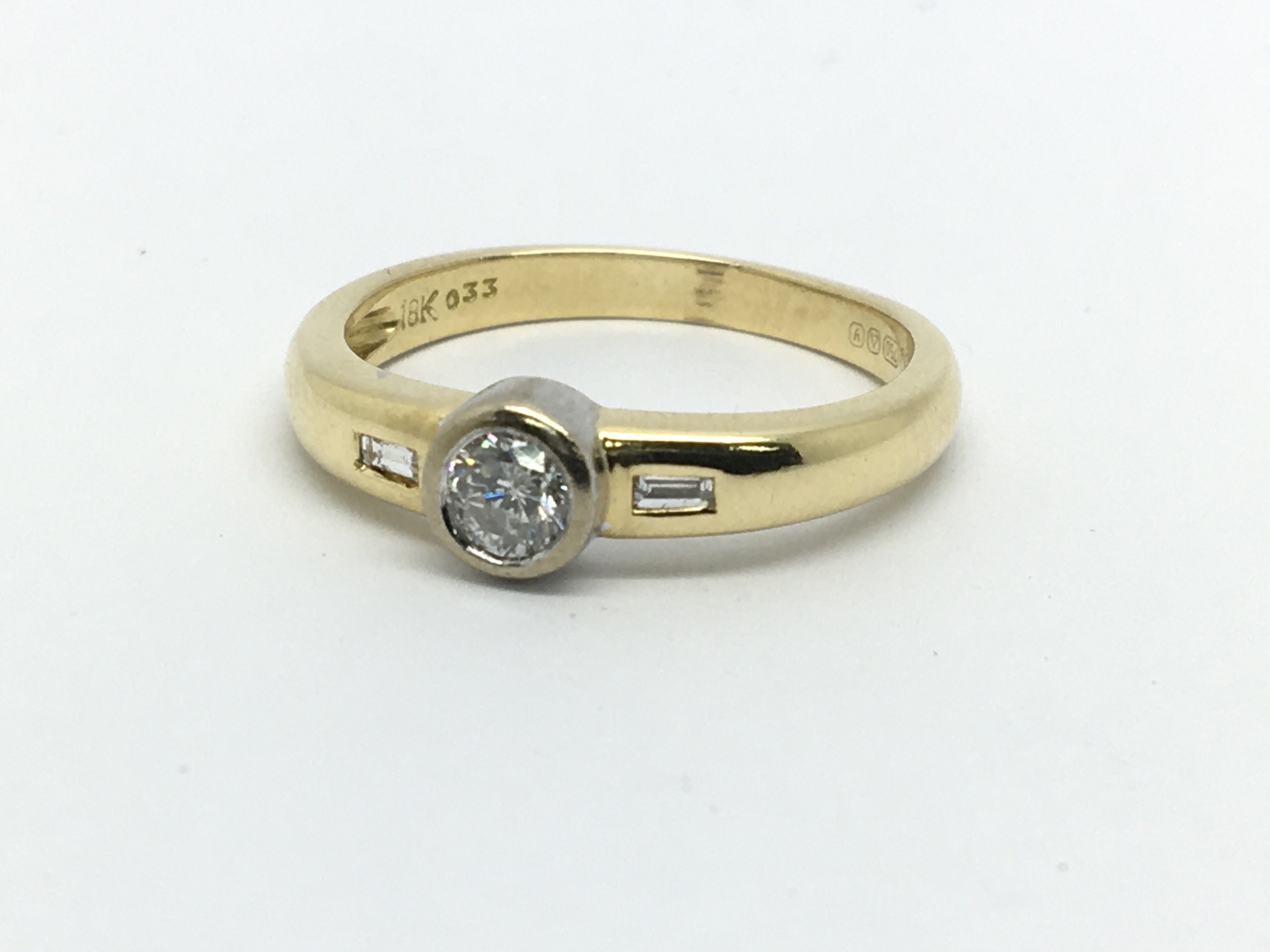 An 18ct gold solitaire diamond ring with diamonds