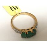 An 18carat gold ring set with three Emeralds with diamonds set into the shank ring size N-O
