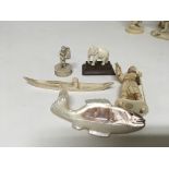 A collection of small carved ivory and bone figures and a mother of pearl carving in the form of a
