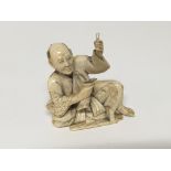 A carved ivory figure of a seated elder some minor