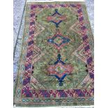 A hand Knotted Turkish or Middle Eastern rug with a red boarder the centre with three Medallion on a