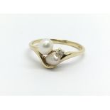 An 18ct gold ring set with two pearls and a small
