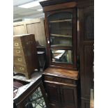 A Victorian walnut bookcase cabinet with a single glazed door with mirror above a drawers and a