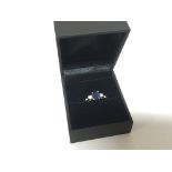 A 9carat white gold ring set with a blue stone possibly a heat treated Sapphire flanked by CZ