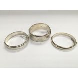 Three silver bangles.