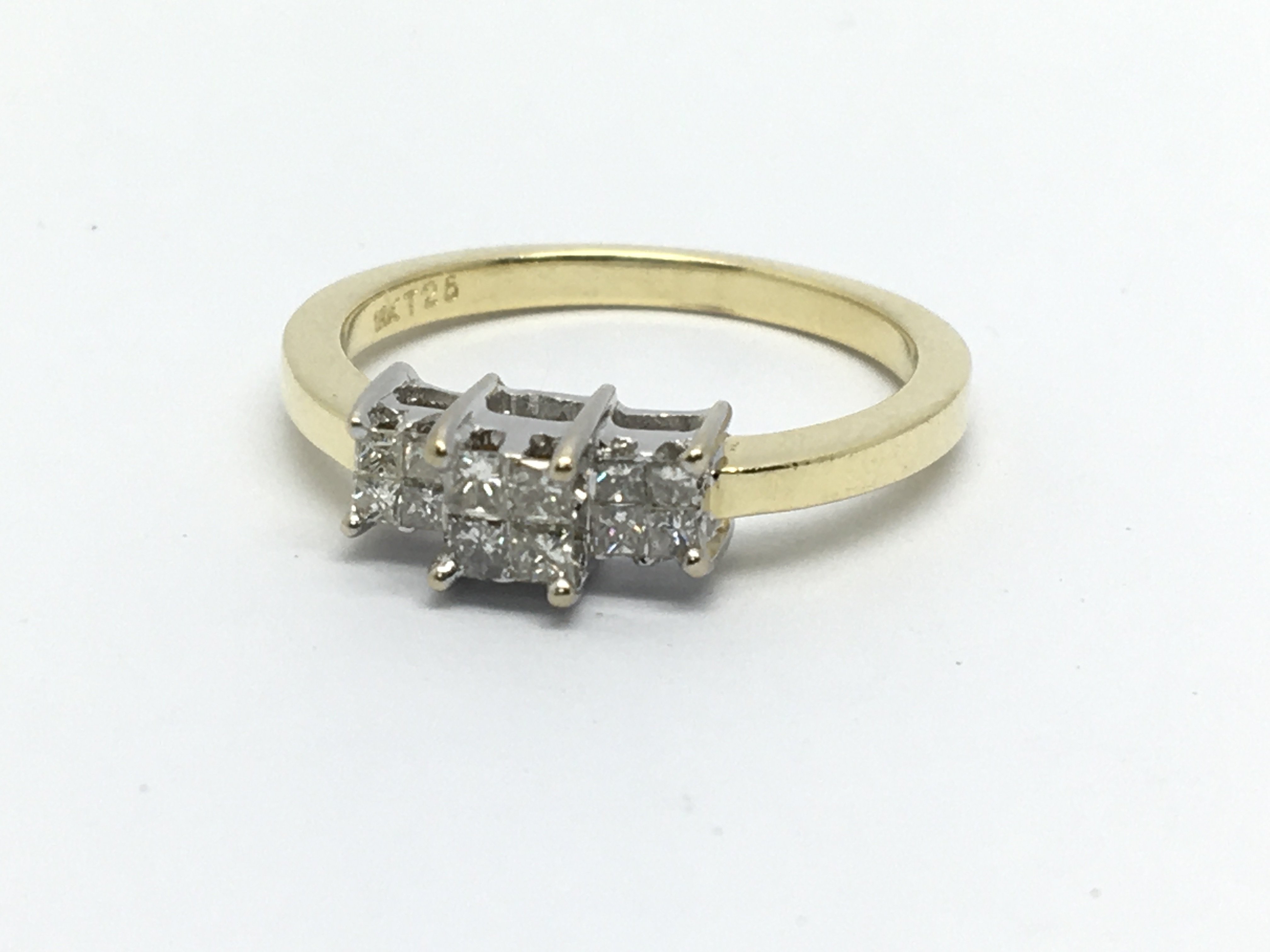 An 18ct gold ring set with twelve princess cuts, a