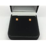 A pair of 9ct gold studs set with a single citrine.