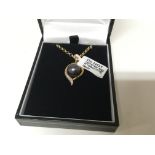 A 9carat gold necklace with attached pendent set with a black pearl and small chip diamonds