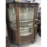 A Quality Edwardian inlaid Mahogany serpentine fronted display cabinet with inlaid panelled doors.