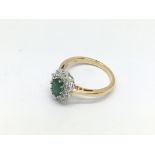 An 18ct gold oval cut emerald and diamond cluster
