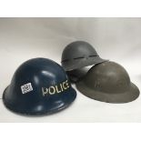 Three tin helmets, including a Police helmet with strap