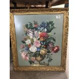 A gilt framed embroidery of flowers.