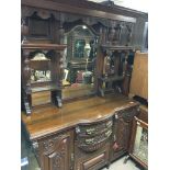 An Edwardian walnut chiffonier with a raised mirrored back with fluted pillars above drawers flanked