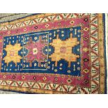 A hand knotted Middle Eastern rug with pink yellow and blue boarder and three central medallion (