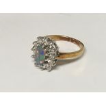 An 18carat gold ring set with an oval opal flanked by brilliant cut diamonds. ring size L.