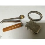 An Amber and gold banded cigar cheroot holder in a silver case a silver bangle and a silver Vesta