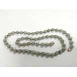 A pale jade necklace with 14k gold clasp.