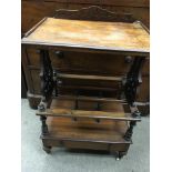 A Victorian walnut Canterbury with three open section and single drawer under on turned legs .