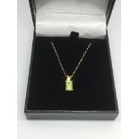 A 9ct gold peridot pendant on a 9ct gold chain